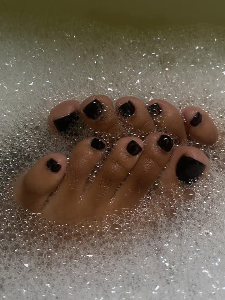 Pedicure by Joy — glossy black polish on freshly done toes